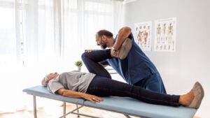 Male Doctor Chiropractor Fixing Womans Leg with Hands Movements 