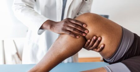 Doctor Examining a Knee of a Woman During an Appointment.