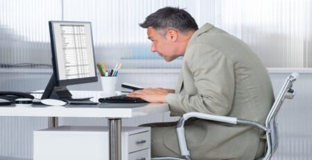 Man Sitting with Poor Posture Using a Computer in Office