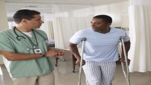 Patient on Crutches Discusses His Progress with His Doctor