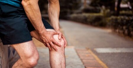 Athlete Holds on to His Knee as He Feels Muscle Strain