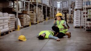 Warehouse Manager Lying Down on the Warehouse Floor After an Accident